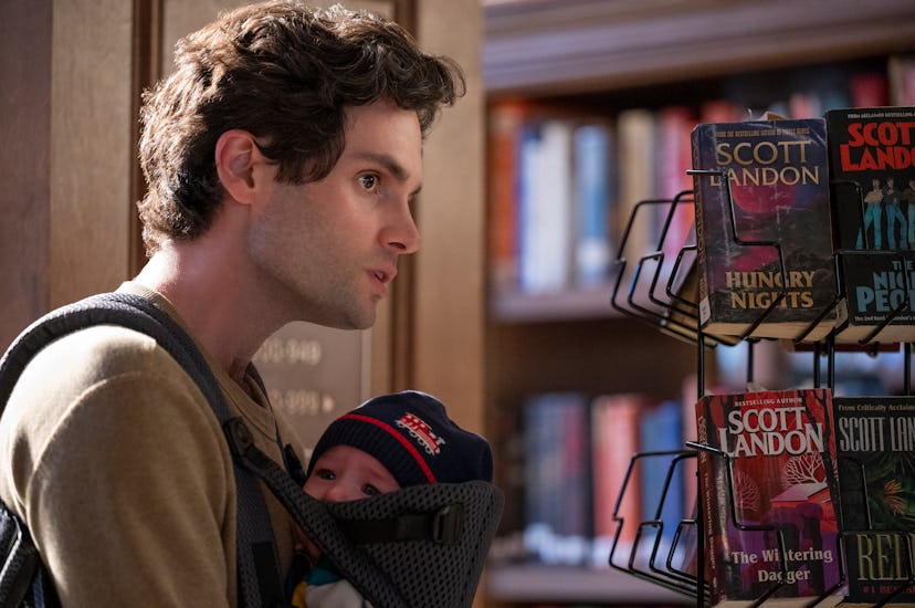 PENN BADGLEY as JOE GOLDBERG in episode 301 of YOU. Joe wars baby Henry in a carrier, and is in a bo...