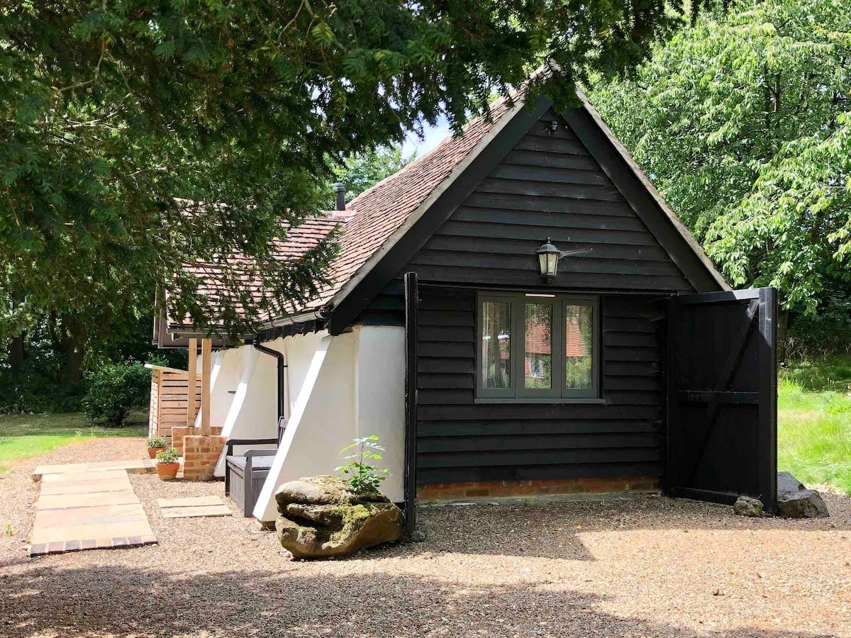The &lsquo;Snuggery&rsquo; cabin in Rochester, Kent in dark brown wood with a short cement porch