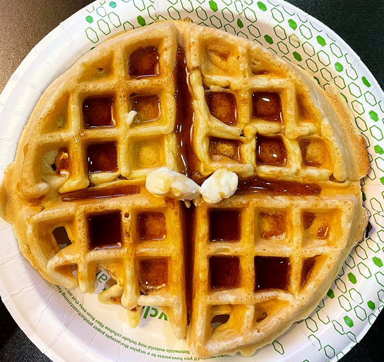 Waffle smothered in maple syrup and two pats of butter.