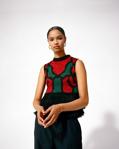 A model wearing a black-red-green knit vest and black trousers by  Lukhanyo Mdingi 