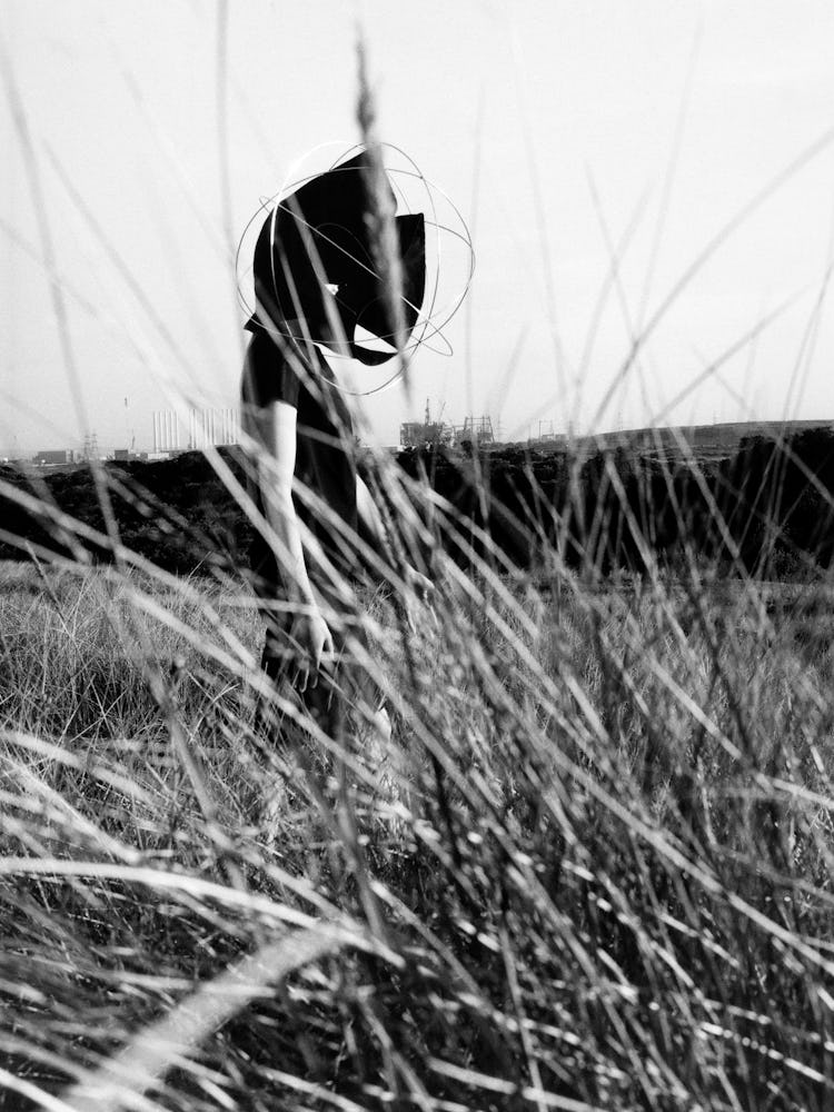 Black and white portrait of model in grass.