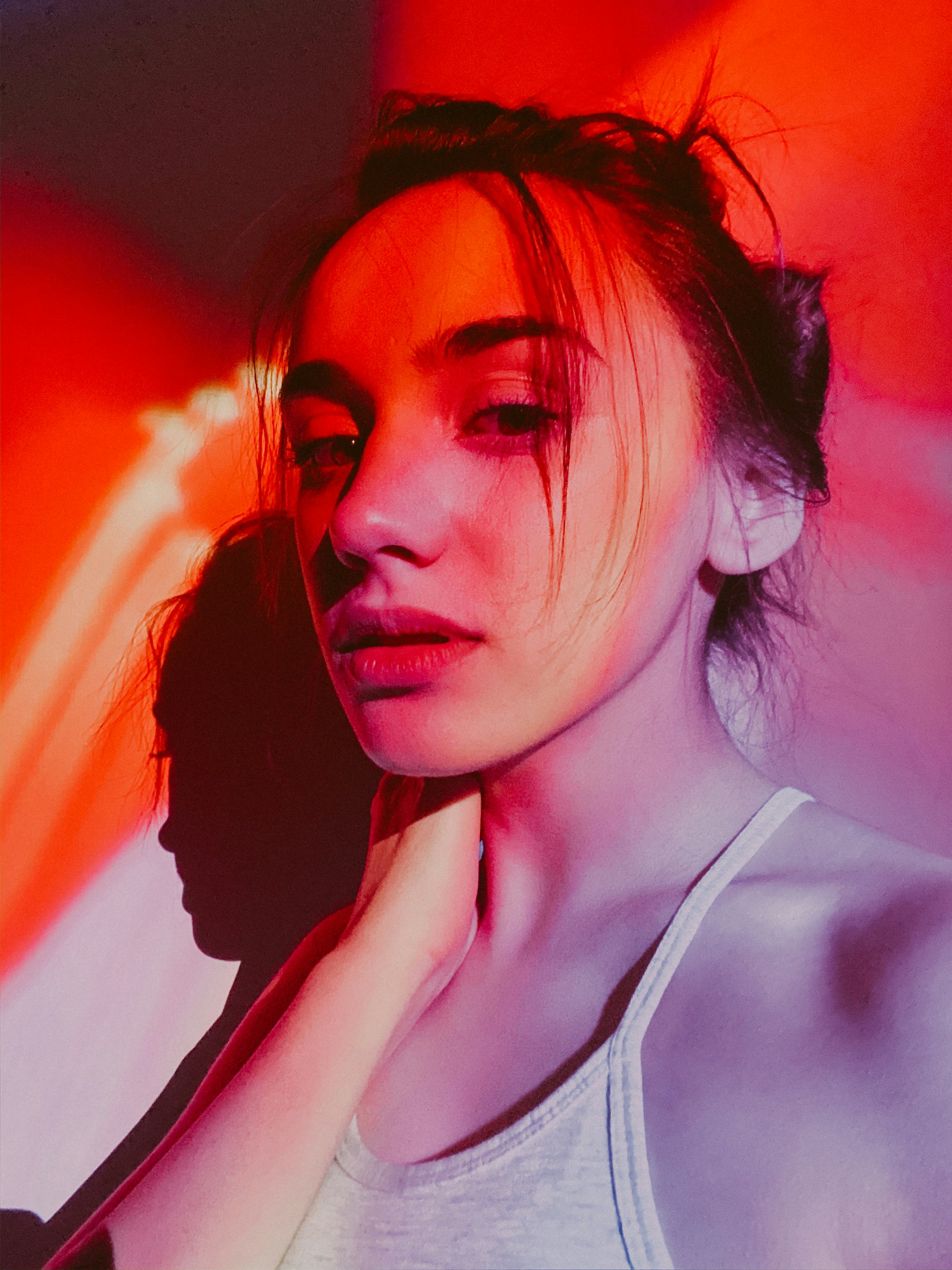 Young woman in neon red lights, her lucky color personality match for her zodiac sign.