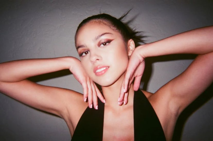 olivia rodrigo posing with arms out and winged liner
