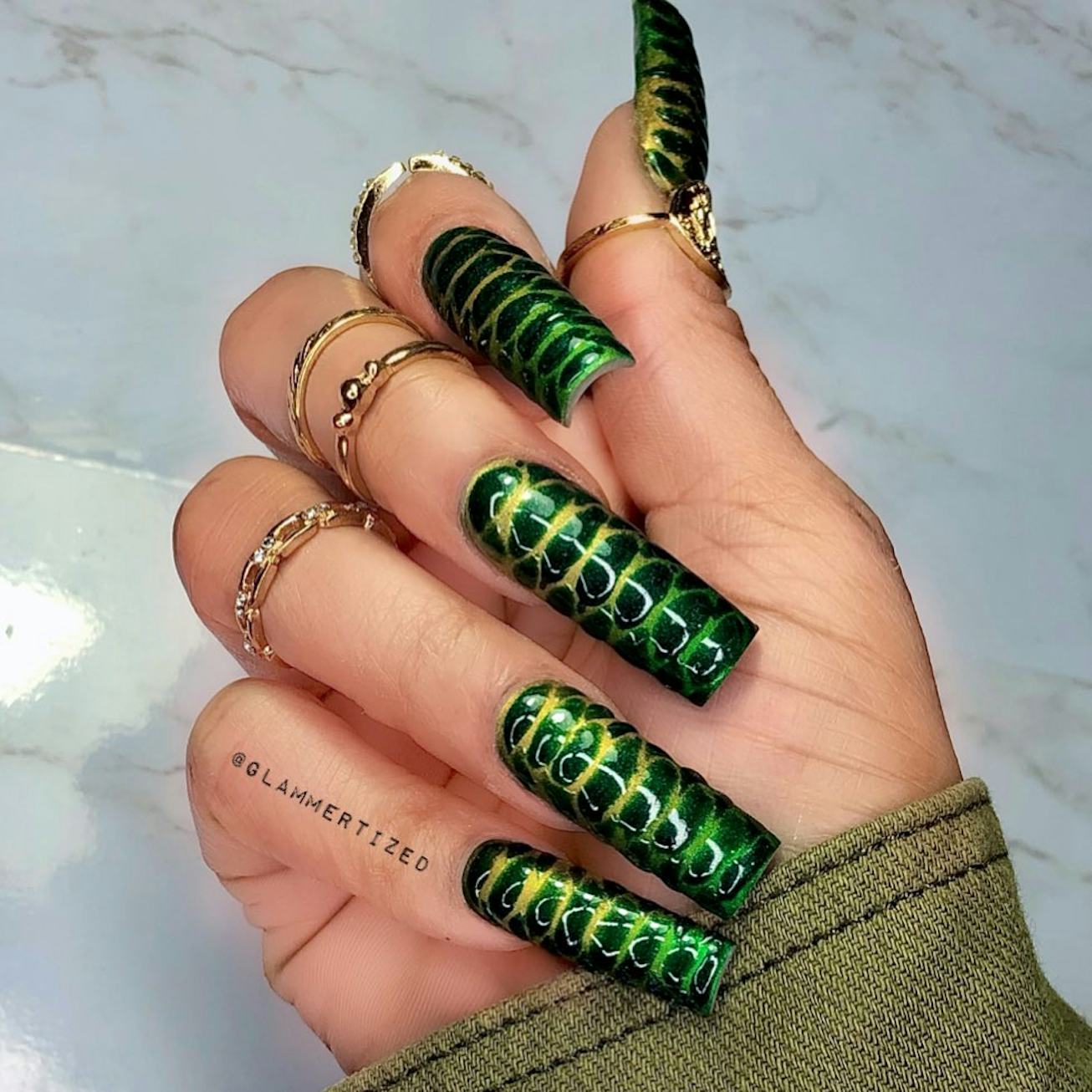 Woman's hand with green and yellow crocodile nail manicure