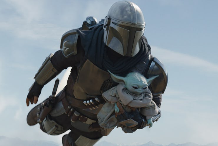Mandalore flying while holding Baby Yoda in his arms