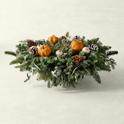Centerpiece with evergreen branches and pumpkins