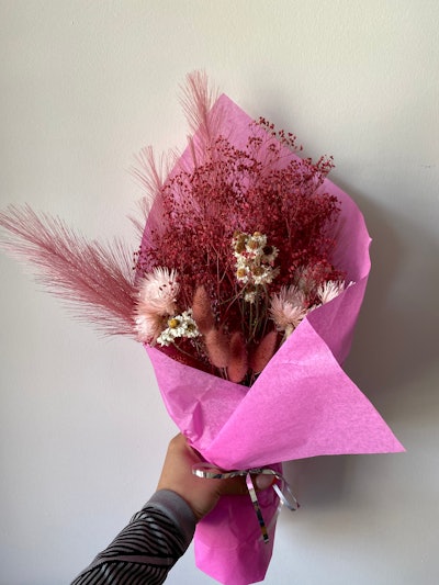 Hand holding bouquet of dried flowers