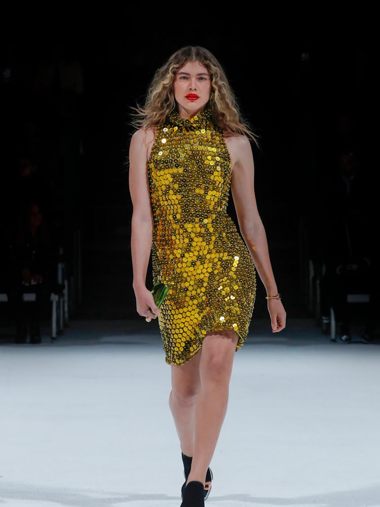 Valentina Sampaio walking the Bottega Veneta spring 2022 runway in a shimmery gold dress.