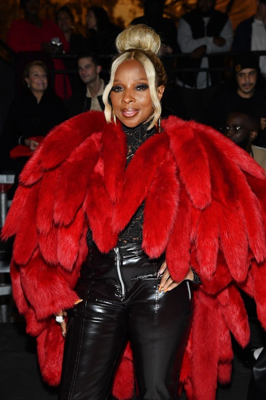 Mary J. Blige in a black outfit with a red faux fur coat at the Bottega Veneta show 