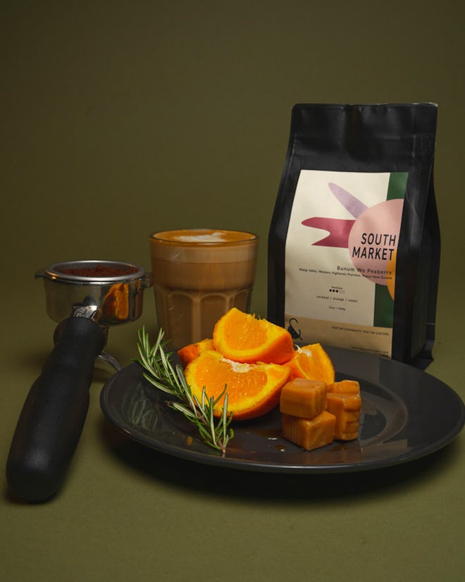 medium roast coffee in bag, photographed with orange slices, caramels and a glass full of coffee