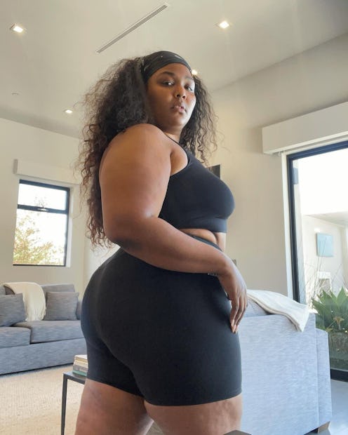Lizzo wears STAX black bike shorts and sports bra on Instagram in 2021.