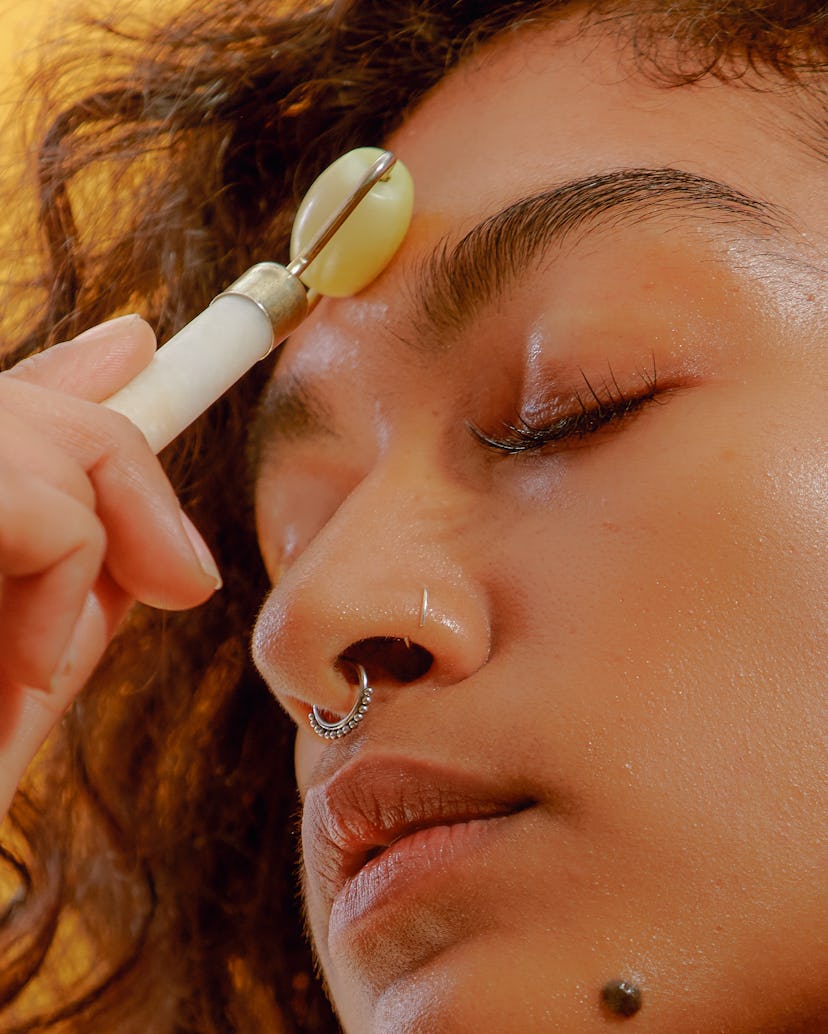 Woman using jade roller on forehead