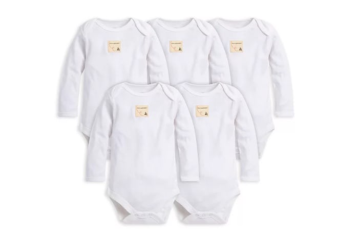 Flat lay of five long-sleeve white baby onesies