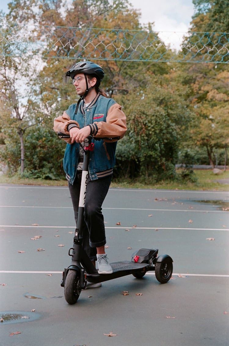 A man standing next to the Gotrax G Pro 3.