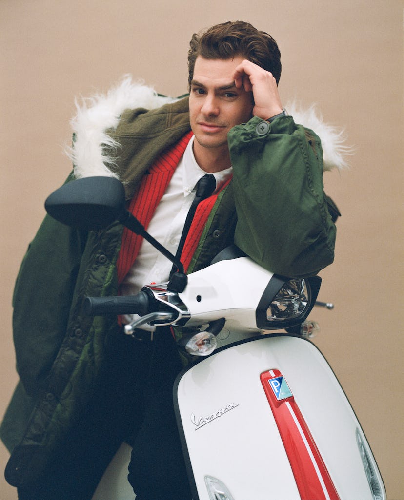Andrew sitting on a white Vespa and wearing a vintage green parka