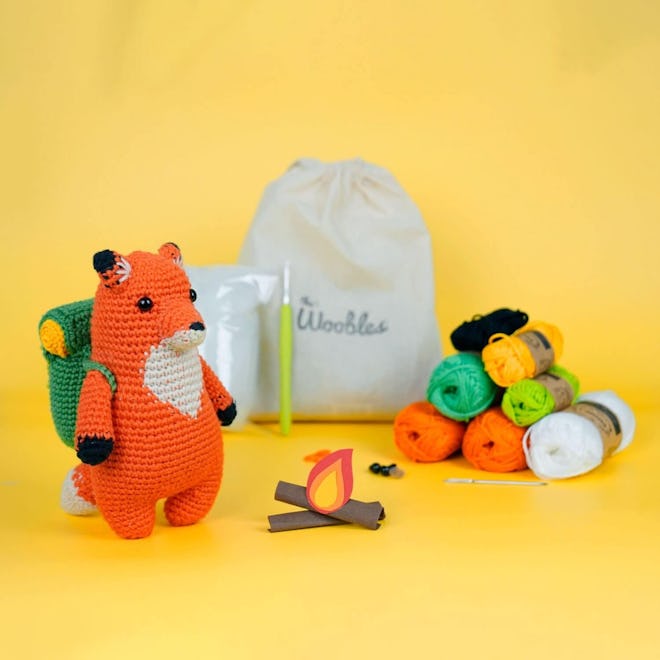 a crochet kit to make a plush fox carrying a backpack