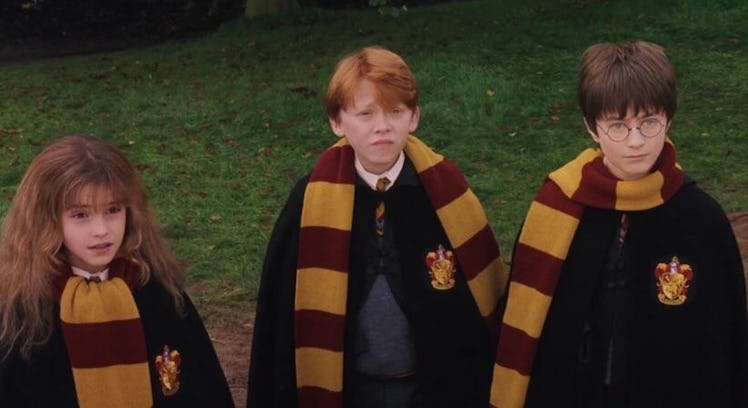 Emma Watson, Rupert Grint and Daniel Radcliffe as Harry, Ron, and Hermione in their Gryffindor scarv...