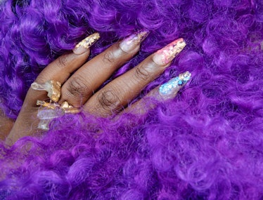 Hand with Coffin Shape Nails in between purple curly hair