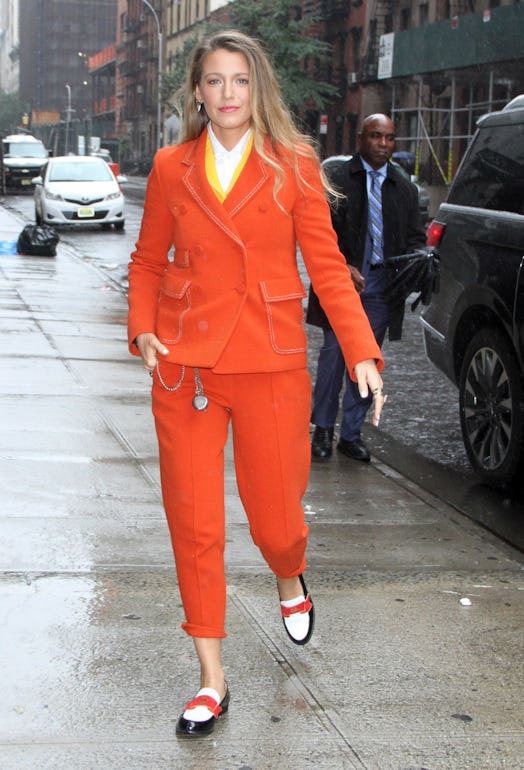 Blake Lively wearing colorful loafers and an orange suit.