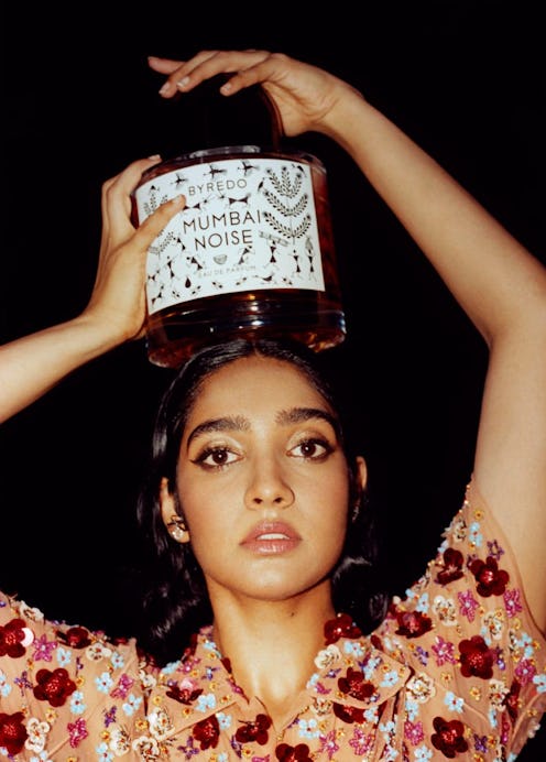 Byredo model holds giant Mumbai Noise bottle on her head.