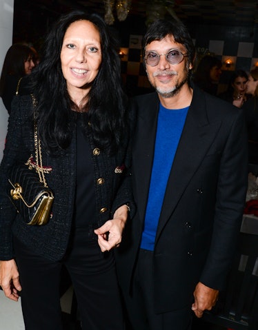 Inez in a black jacket and a gold bag and Vinoodh in a black blazer and a blue shirt