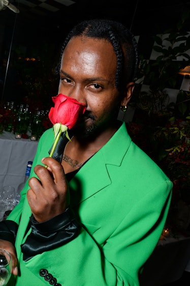 Edvin Thompson holding a red rose in a green suit