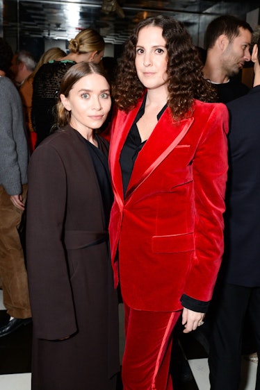Ashley Olsen in a brown suit and black shirt, and Sara Moonves in a red suit and a black shirt