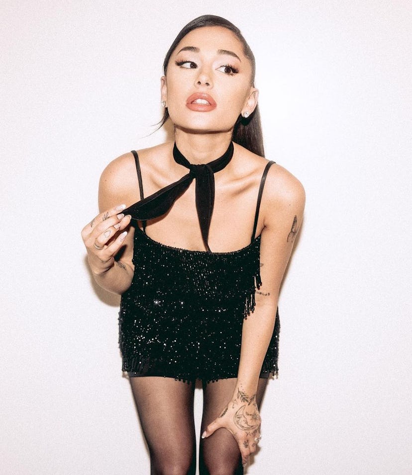 Ariana Grande posing against wall with neckerchief 