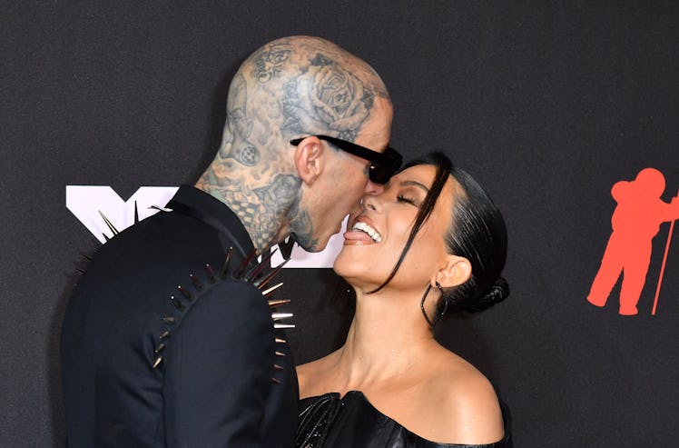 Travis Barker and Kourtney Kardashian kissing during a red carpet event