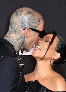 Travis Barker and Kourtney Kardashian kissing during a red carpet event