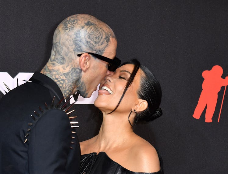 Travis Barker and Kourtney Kardashian kissing during a red carpet event