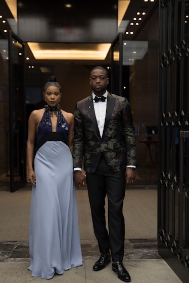 Gabrielle Union in a blue-navy dress with a black choker and Dwyane Wade in a black suit and a white...