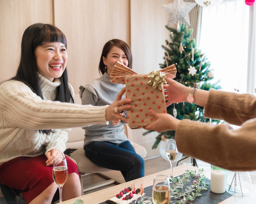 happy friends exchanging secret santa gifts under $5