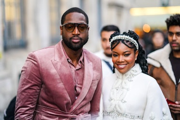 Gabrielle Union in a white dress and diamond tiara and Dwyane Wade in a pink velvet suit