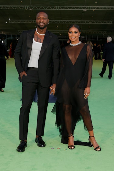 Gabrielle Union in a black tulle dress and diamond choker and Dwyane Wade in a black suit and a whit...