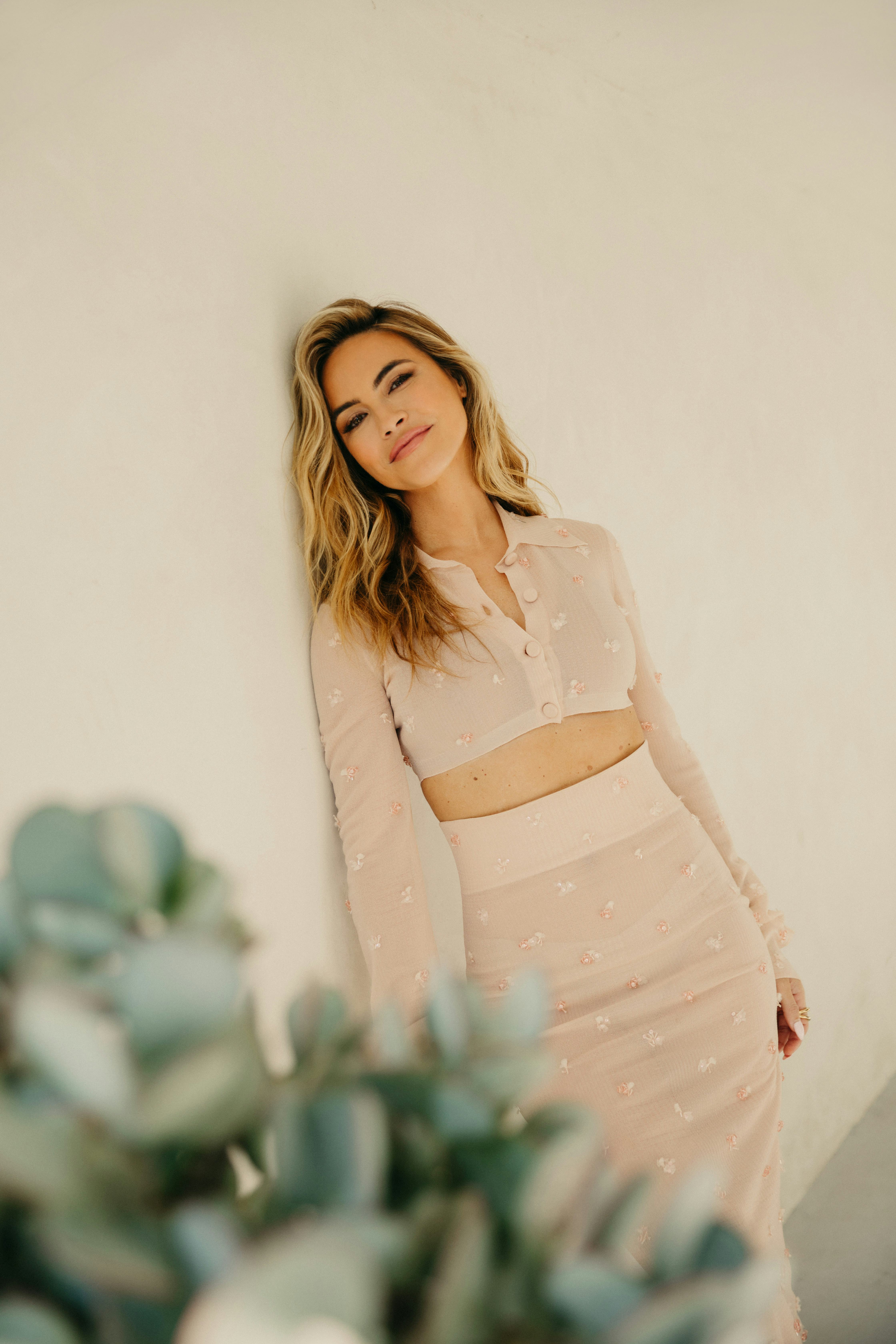 Chrishell Stause leaned against the wall in a white Fendi matching skirt and cropped button-up