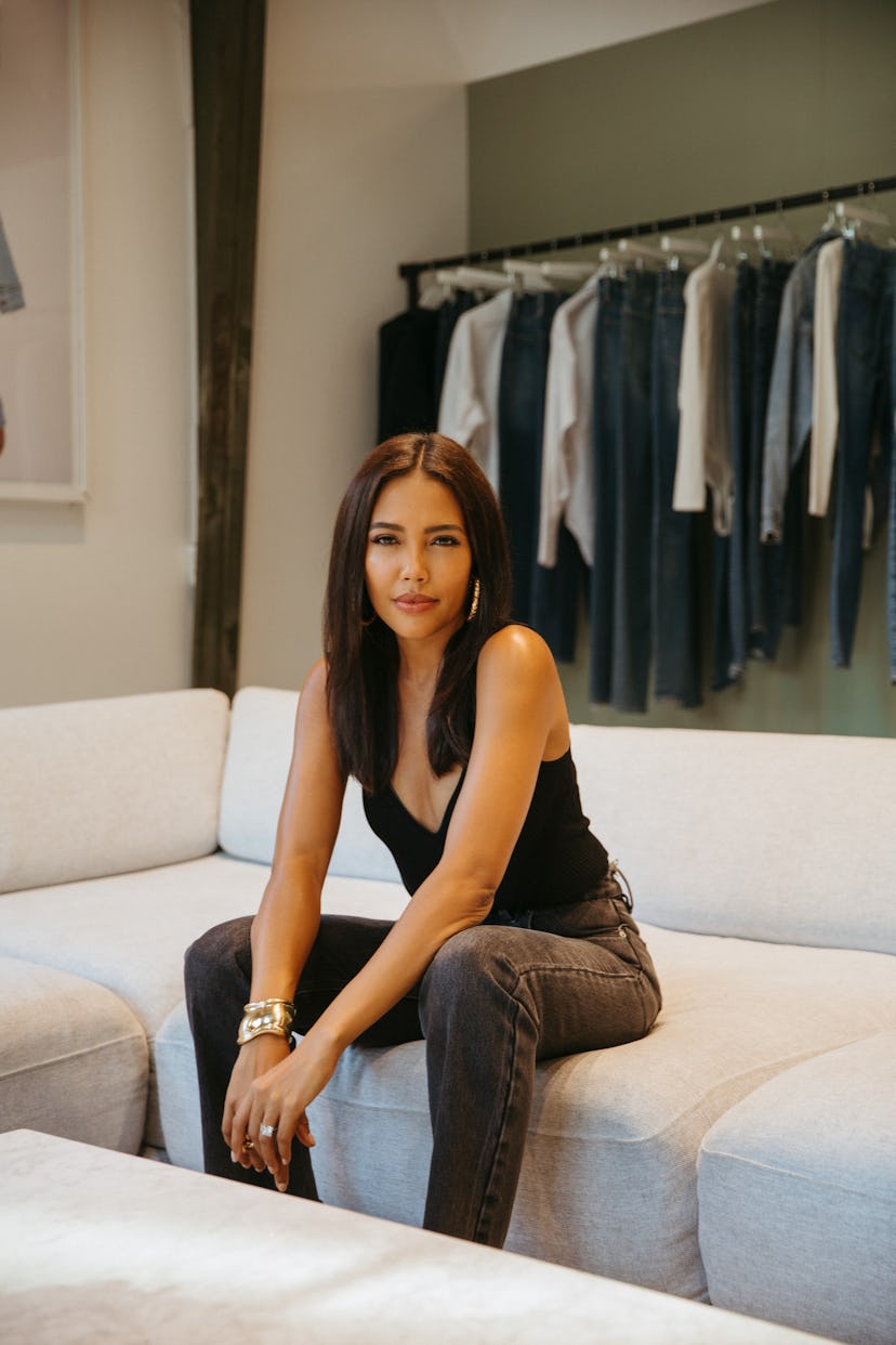 Good American CEO Emma Grede posing on a white sofa