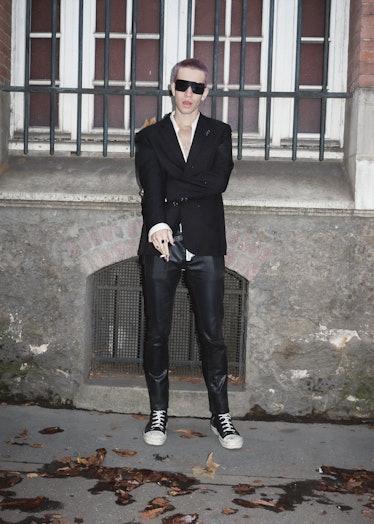 Showgoer at Paris Fashion Week wears black suit.