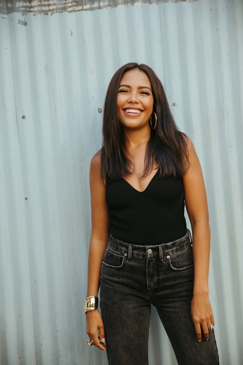 Emma Greede smiling in front of a sheet metal wall