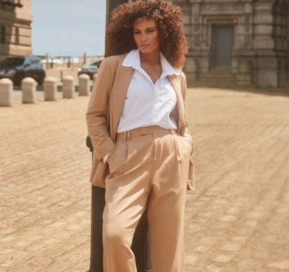 Model wears a tan two-piece suit and white collared shirt from 11 Honoré's collection with Nordstrom...