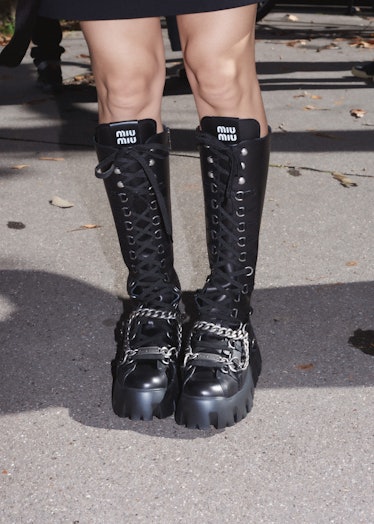 Showgoer in black Miu Miu combat boots outside the Miu Miu spring 2022 show at Paris Fashion Week.