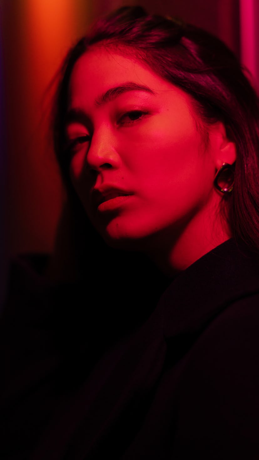 Young woman lit by red neon light as Jupiter retrograde 2021 comes to an end.