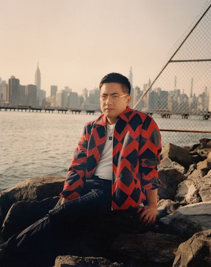 Bowen Yang wearing a Bode jacket, Sunspel T-shirt, Berluti pants, his own  glasses and jewelry 