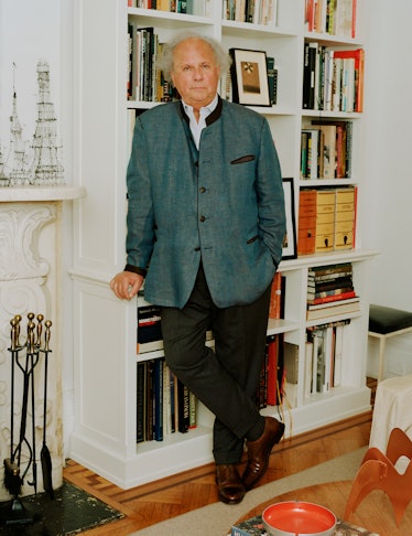 Graydon Carter leaning against a bookshelf in his office