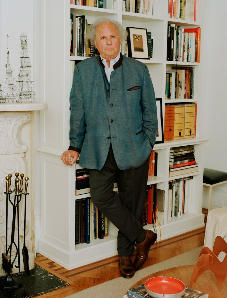 Graydon Carter leaning against a bookshelf in his office