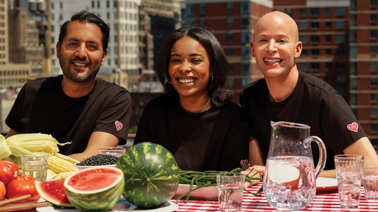 Three models posing in black t-shirts for Michael Kors Watch Hunger Stop Capsule Collection 2021.