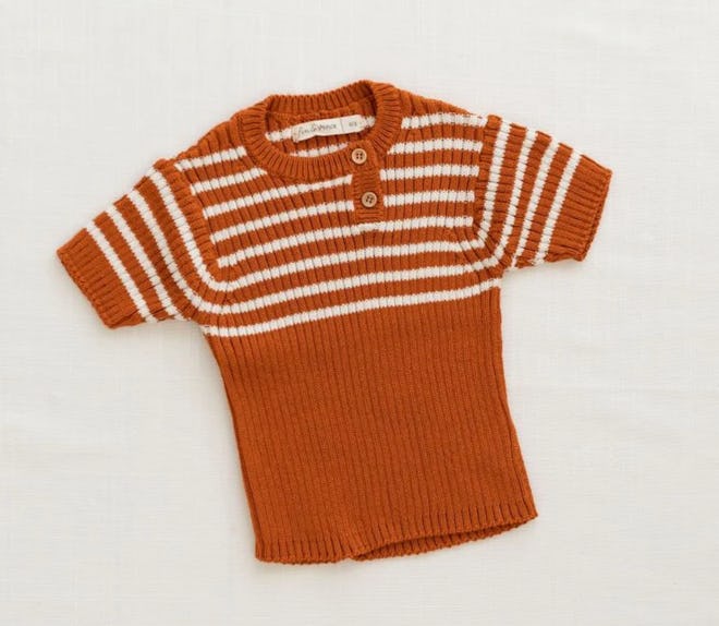 Image of a child-size short-sleeve, orange knit top with white horizontal stripes on the upper half....