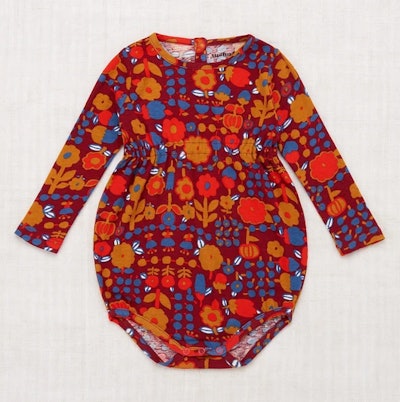 Image of a child-size red onesie with autumnal floral print.