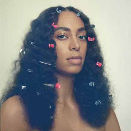 Full-profiled Solange with a lot of pink and blue hair clips on the poster of the "A Seat at the Tab...