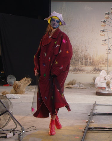 Model wears red coat from Maison Margiela spring 2022 collection. 